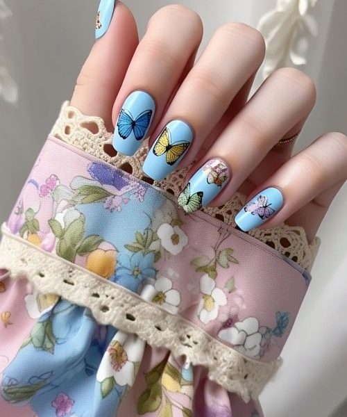 16. A Whimsical Hand With Blue Spring Nails In Baby Blue, Decorated With Delicate Butterfly Decals, Emerging From A Soft Floral Long Sleeve