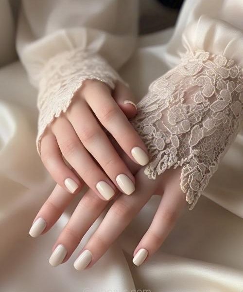 2. A Single Hand With Short Nails Featuring Classic French Tips Soft Pink Base And Thin White Tips, Wearing Soft Long Sleeves.
